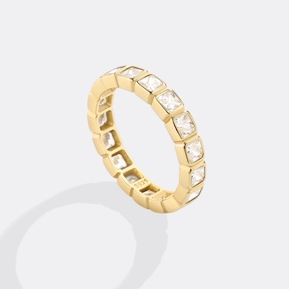 Gold ring with embedded stones on a light gray background