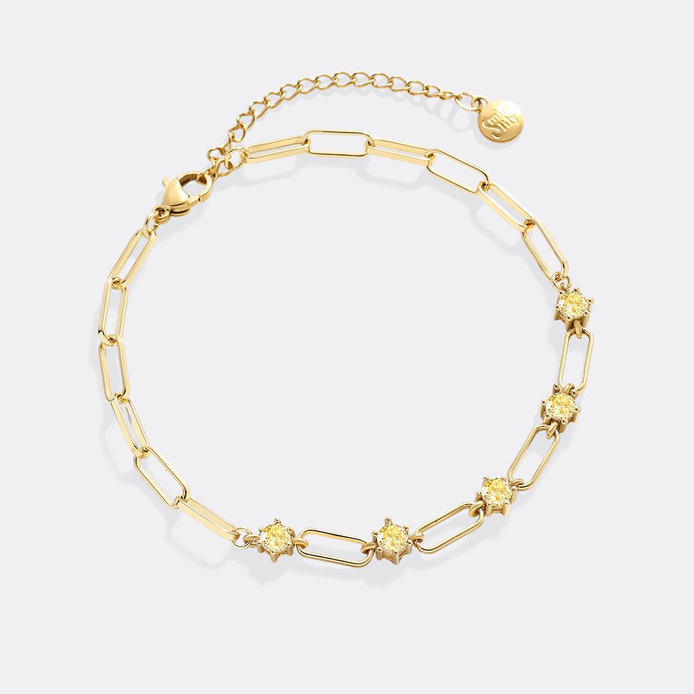 Gold bracelet with floral links on a white background
