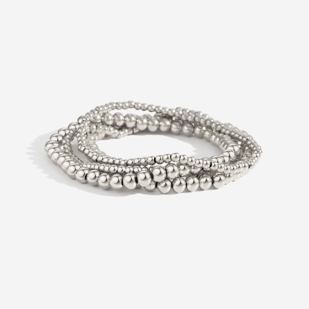 A set of gold-colored bead bracelets with a twisted design, featuring different shades of gold and a shiny finish.