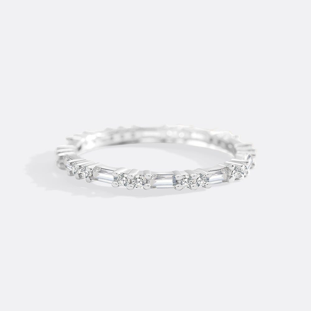 Silver ring with embedded diamonds on a light gray background