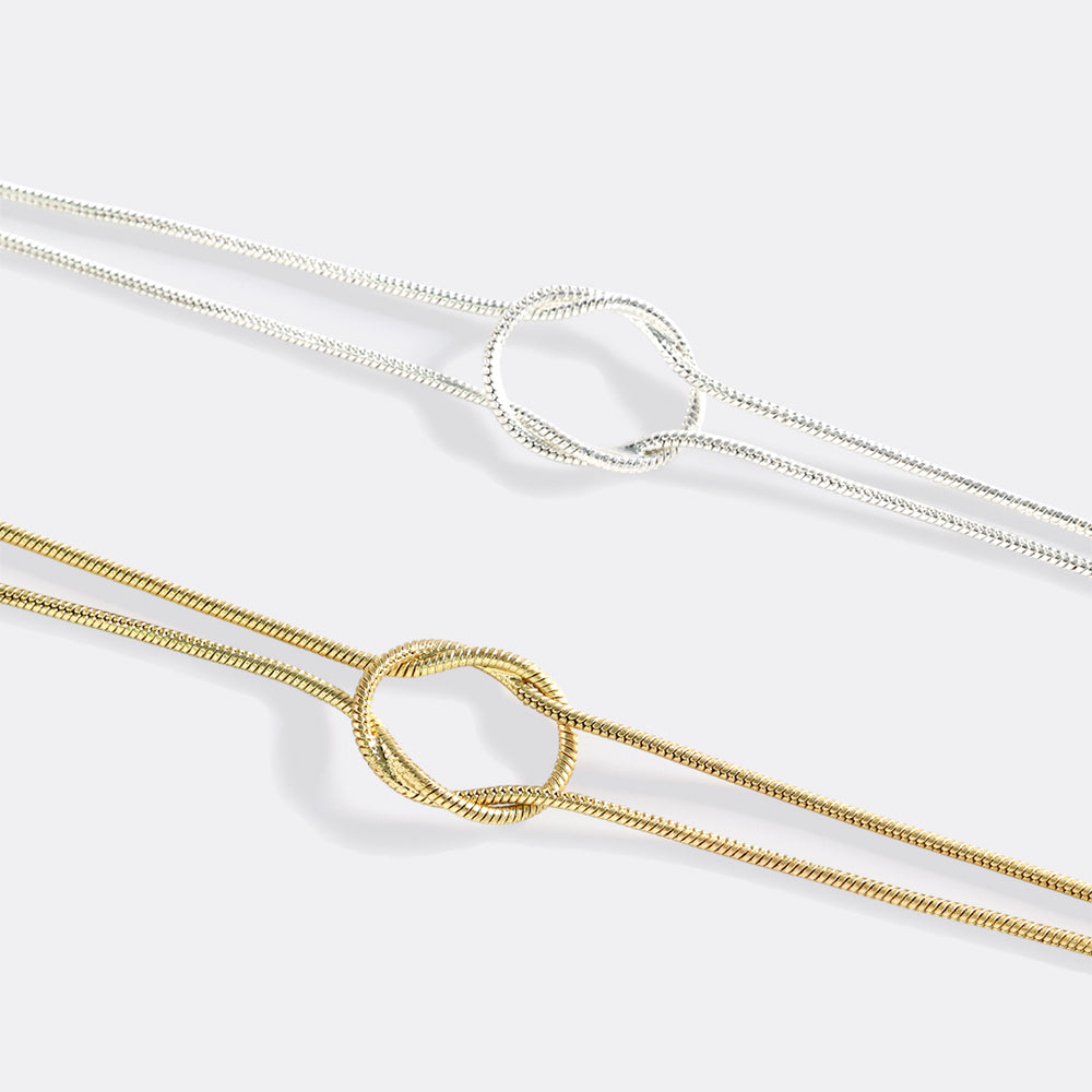 Two gold necklaces with heart-shaped clasps on a white background