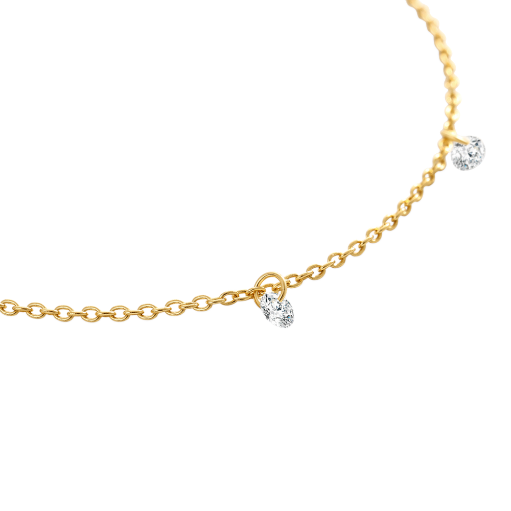 Gold chain necklace with small diamond pendants on a white background