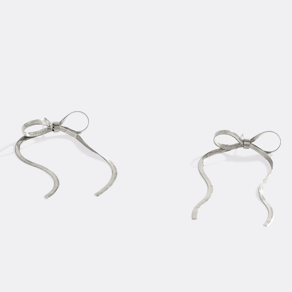 Silver bow-shaped earrings on a light gray background