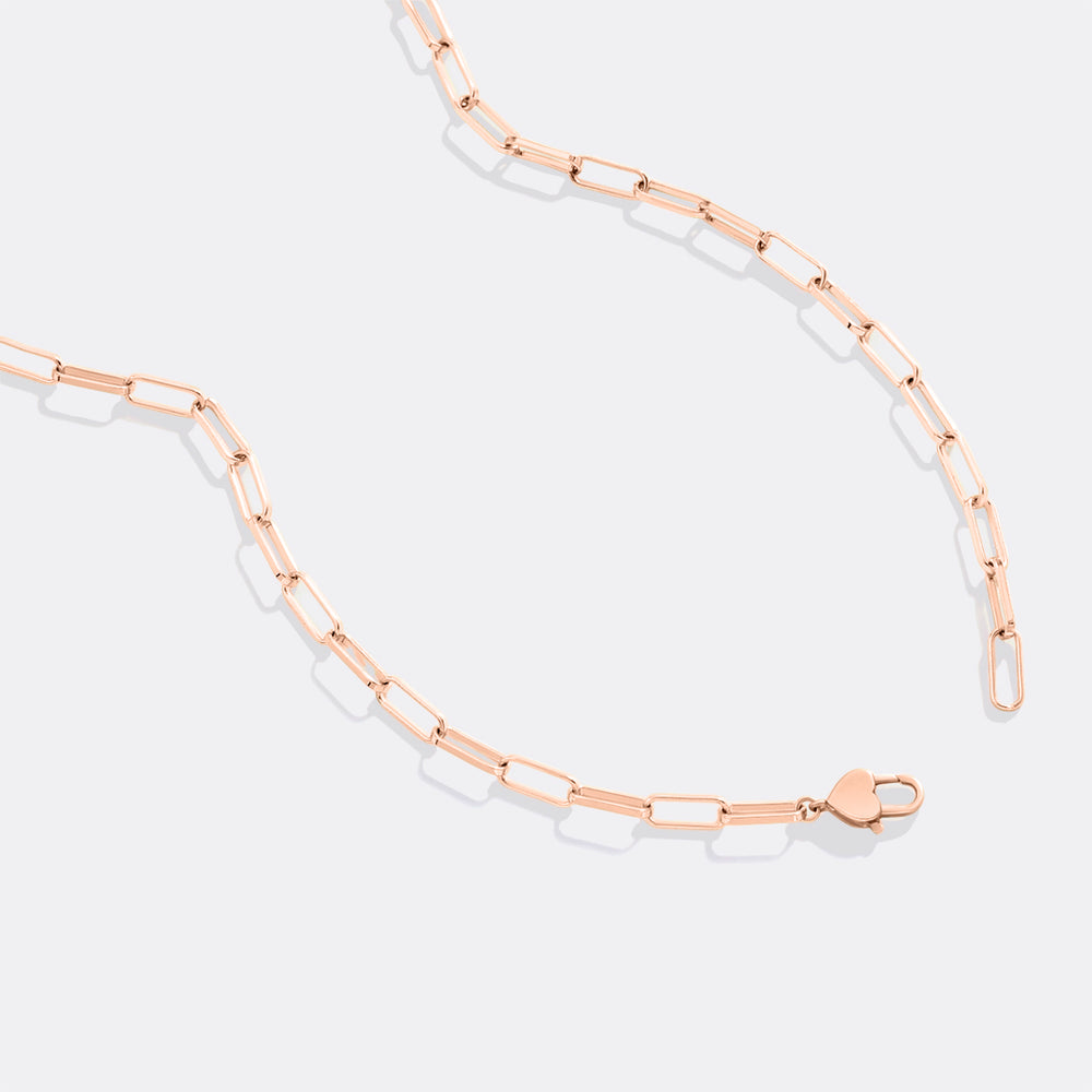 Rose gold chain necklace on a light gray background