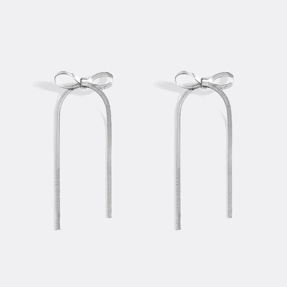 Pair of silver bow earrings on a light gray background