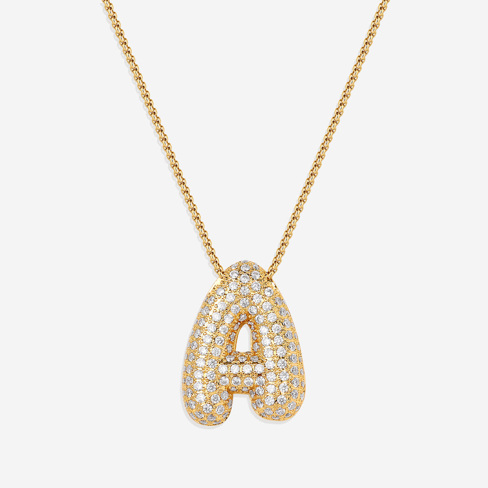 A gold initial necklace with a bubble-shaped pendant covered in zircon stones, displayed against a black background.