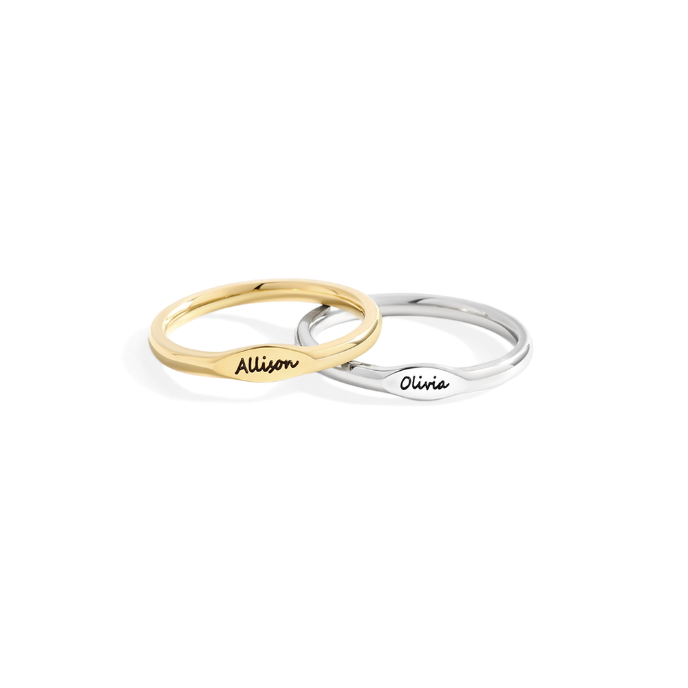 Two rings, one gold and one silver, with engraved names on a white background
