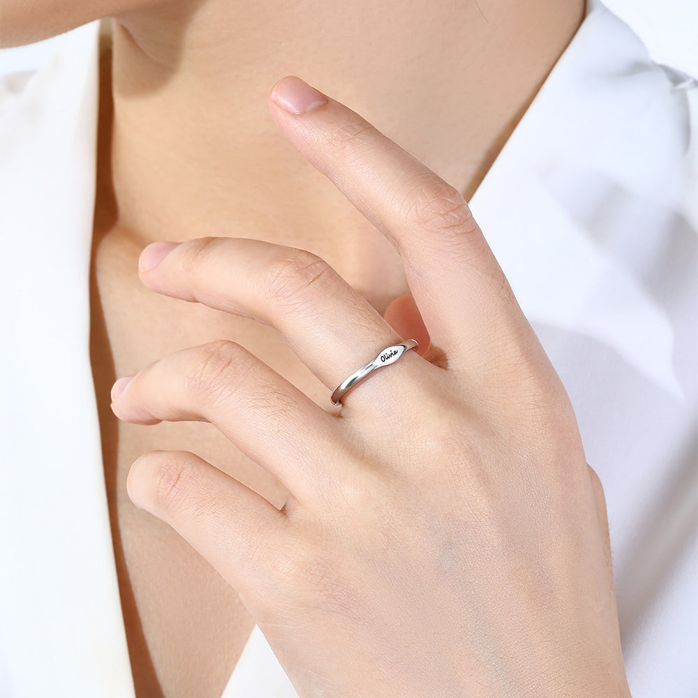Hand wearing a silver ring with a white background