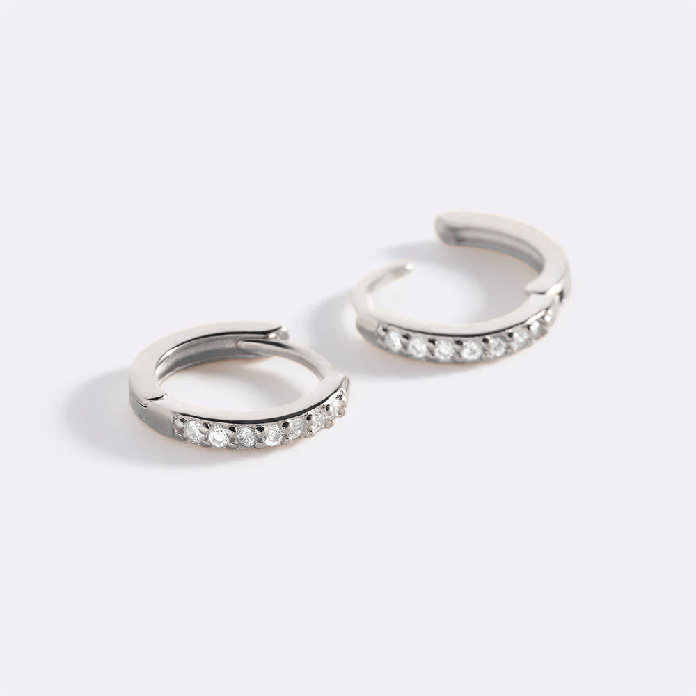 Pair of silver hoop earrings with embedded stones on a white background