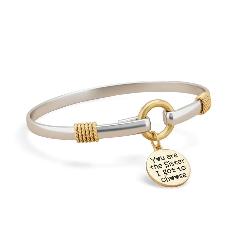 Bracelet with gold and silver design and a charm on a white background