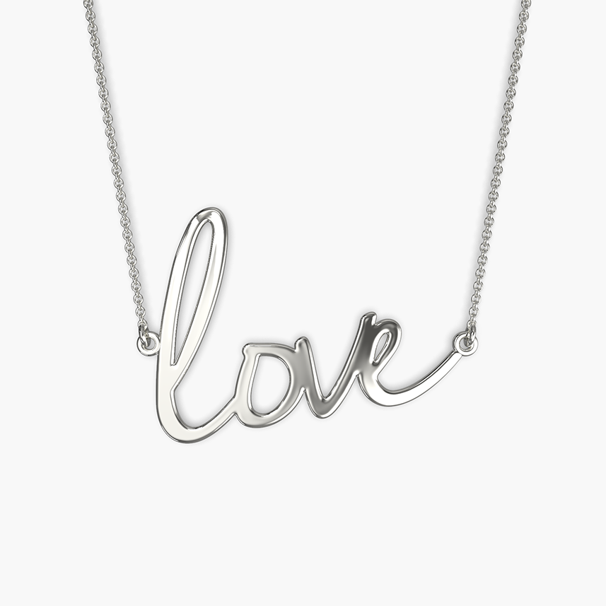 A person wearing a white V-neck top showcasing a gold-colored necklace with the word 'love' written in cursive script.