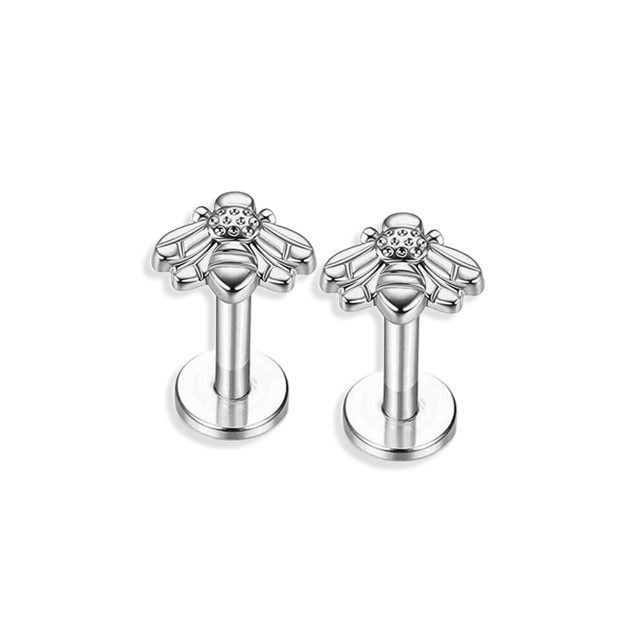 A single gold-colored labret stud with a bee design on a post.